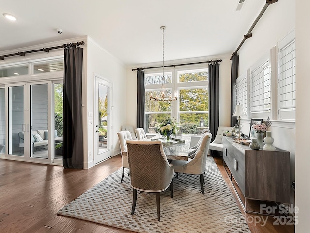 dining room with crown molding, dark hardwood / wood-style floors, and a notable chandelier