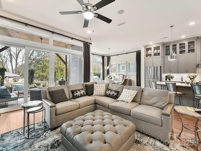 living room with light hardwood / wood-style flooring and ceiling fan