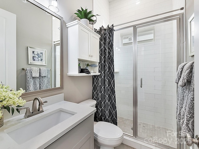 bathroom featuring vanity, an enclosed shower, and toilet