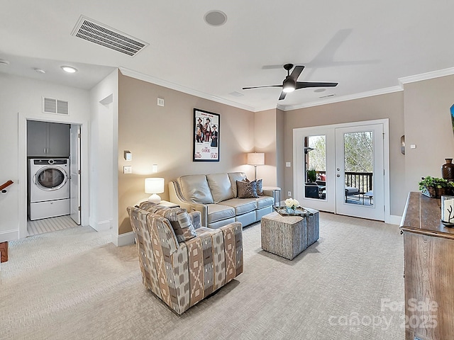 carpeted living room featuring washer / clothes dryer, ornamental molding, french doors, and ceiling fan