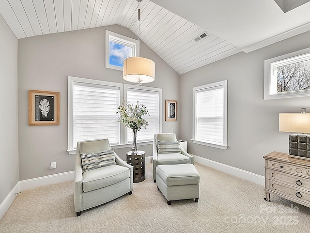 sitting room featuring a wealth of natural light, lofted ceiling, and light colored carpet