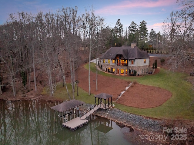 dock area with a water view and a lawn