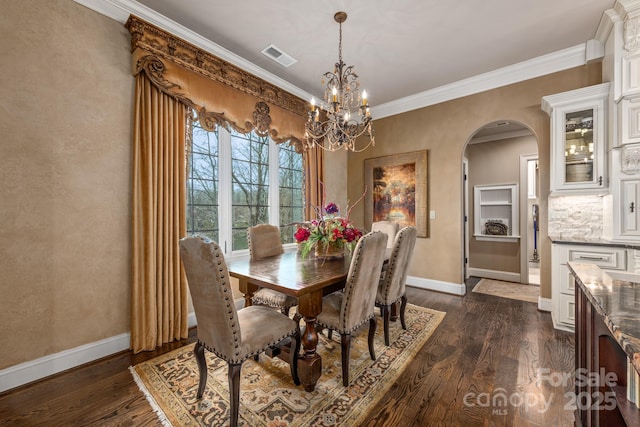 dining room with dark wood-type flooring, crown molding, and a chandelier