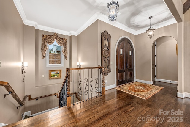 foyer entrance with crown molding and dark wood-type flooring