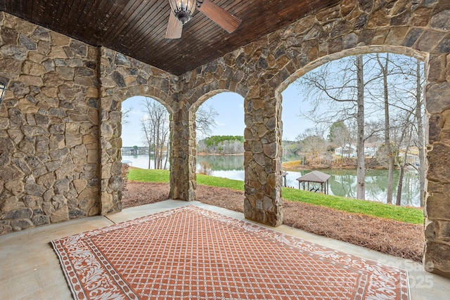 view of patio / terrace featuring a water view and ceiling fan