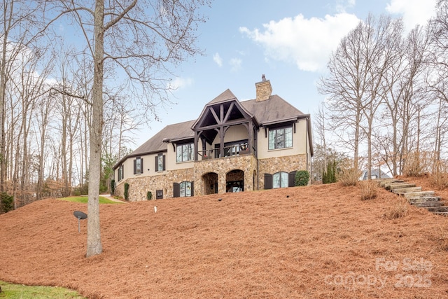 english style home featuring a balcony