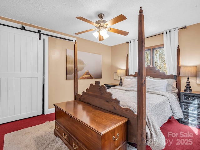 carpeted bedroom featuring ceiling fan, a barn door, and a textured ceiling