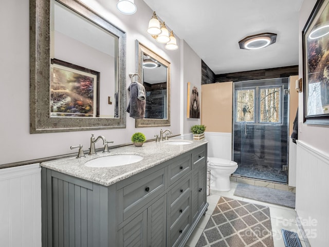 bathroom featuring vanity, a shower with shower door, and toilet