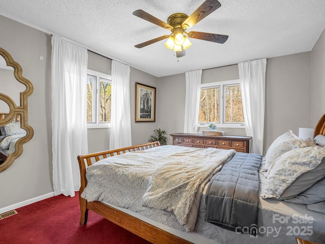 carpeted bedroom with ceiling fan and a textured ceiling