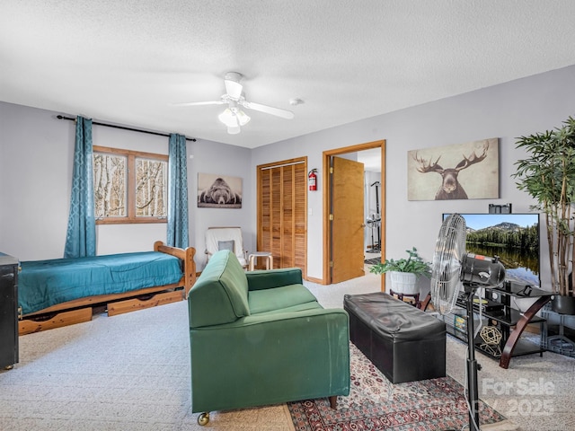 living room with ceiling fan, a textured ceiling, and carpet flooring