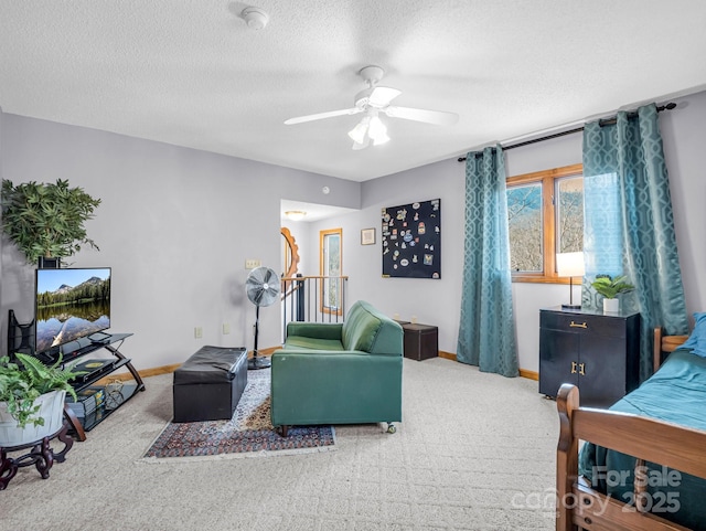 carpeted living room featuring ceiling fan and a textured ceiling