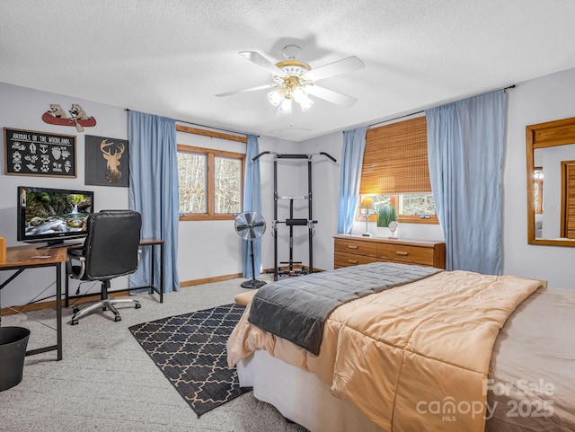 bedroom featuring ceiling fan, light colored carpet, and a textured ceiling