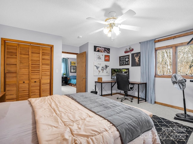 bedroom featuring ceiling fan, a closet, carpet, and a textured ceiling