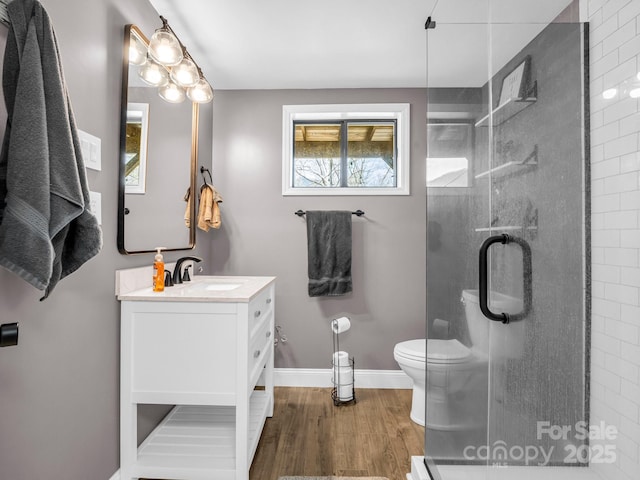 bathroom with walk in shower, vanity, toilet, and hardwood / wood-style flooring