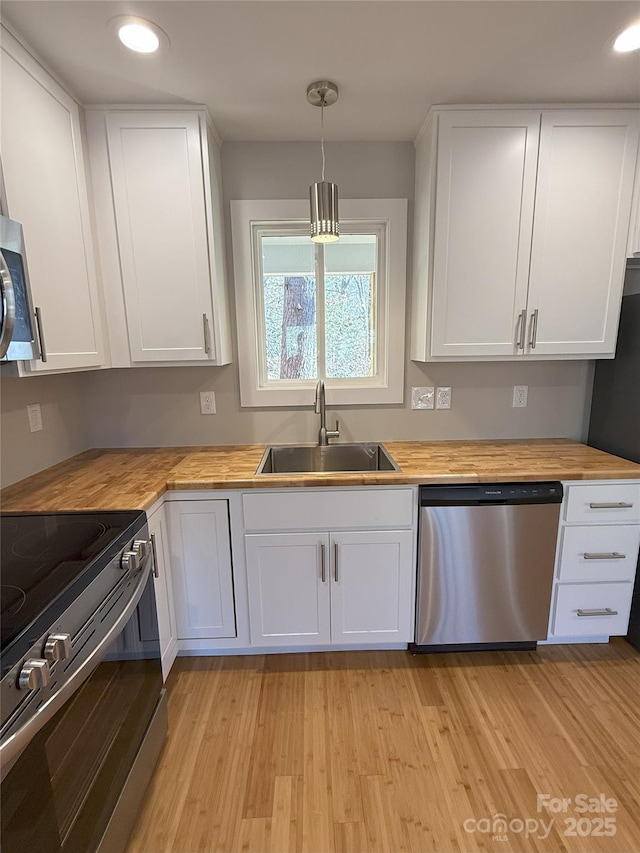 kitchen with sink, white cabinets, and appliances with stainless steel finishes