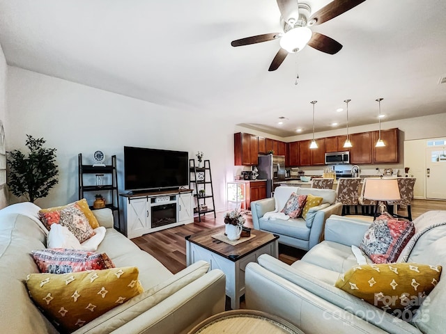 living room with dark wood-type flooring, ceiling fan, and sink