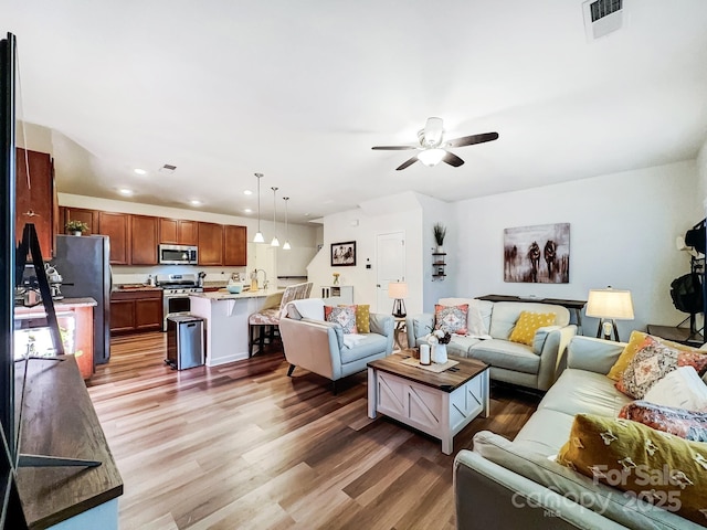 living room featuring dark wood-type flooring and ceiling fan