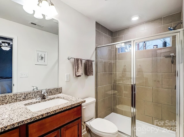 bathroom with vanity, an enclosed shower, and toilet