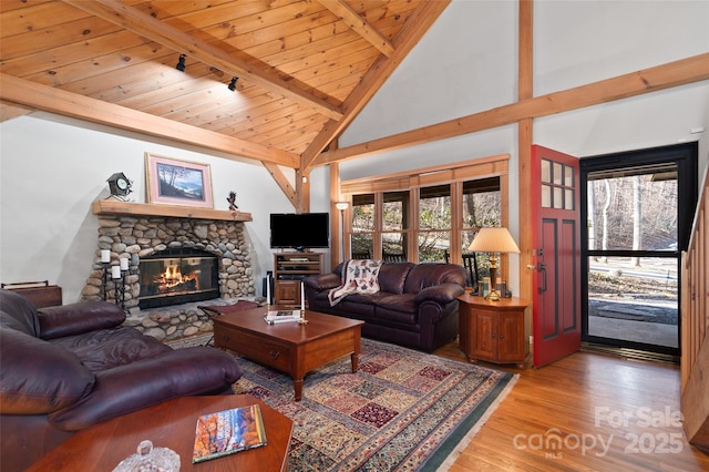 living room with high vaulted ceiling, a fireplace, beamed ceiling, hardwood / wood-style flooring, and wood ceiling