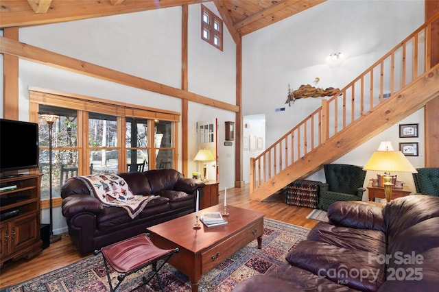 living room with wood ceiling, high vaulted ceiling, and light hardwood / wood-style flooring