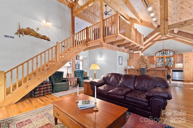 living room with wood-type flooring, beam ceiling, high vaulted ceiling, and a wealth of natural light