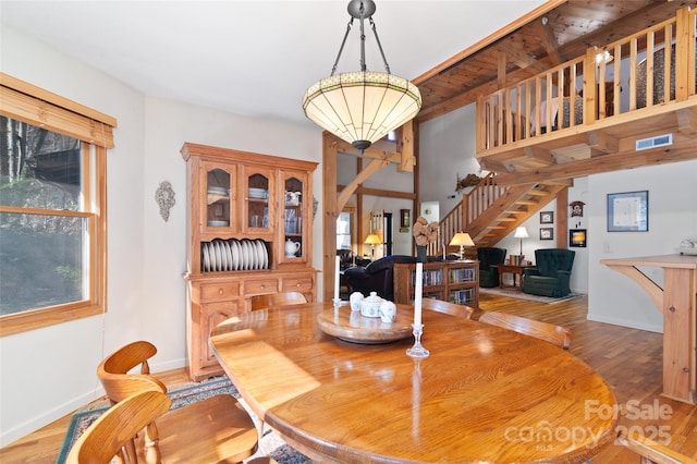 dining area featuring a wealth of natural light, hardwood / wood-style floors, and beam ceiling