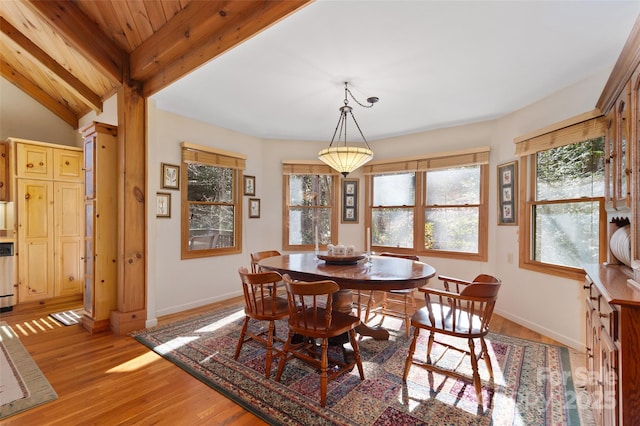 dining space with vaulted ceiling with beams and light hardwood / wood-style floors