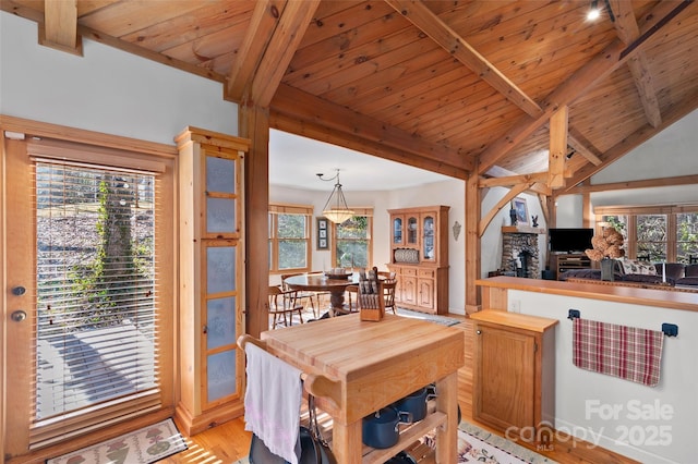 dining area featuring vaulted ceiling with beams, wood ceiling, and light wood-type flooring