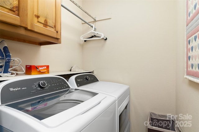 clothes washing area featuring cabinets and washer and dryer