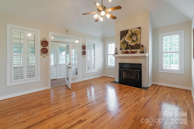 unfurnished living room featuring ceiling fan, light hardwood / wood-style floors, and vaulted ceiling