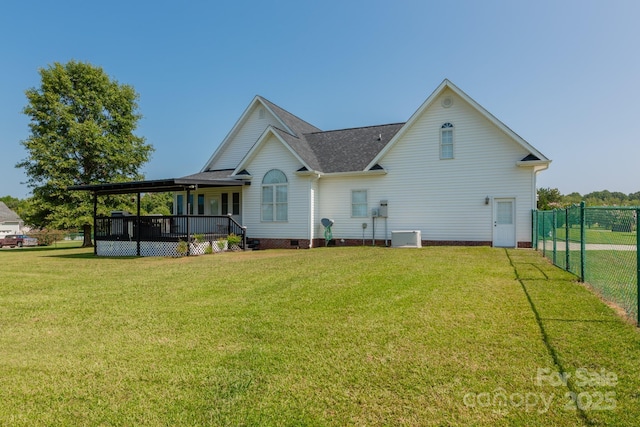 rear view of property featuring a yard and covered porch