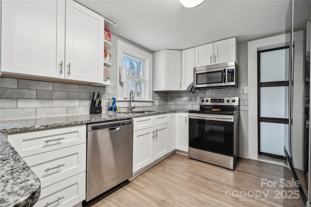 kitchen featuring sink, light stone countertops, white cabinets, and appliances with stainless steel finishes