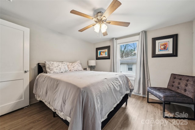 bedroom with dark hardwood / wood-style flooring and ceiling fan