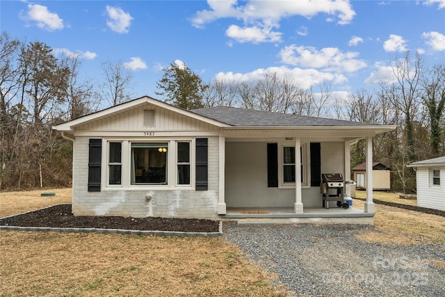 view of front of home with a porch and a storage unit