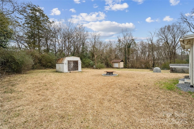 view of yard with a storage shed and a fire pit