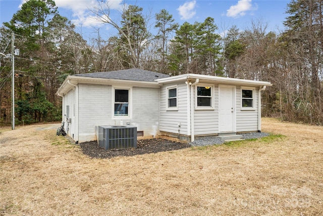 rear view of house featuring a yard and central AC unit