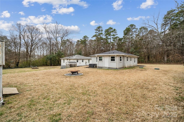 exterior space with an outbuilding, an outdoor fire pit, and central AC