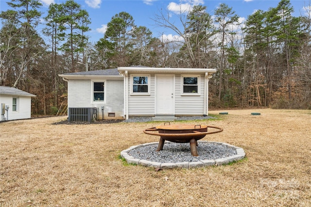 view of outbuilding featuring central AC unit, a fire pit, and a yard