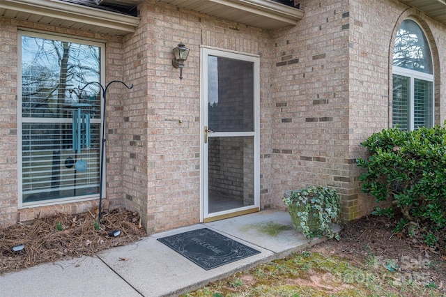 entrance to property featuring brick siding