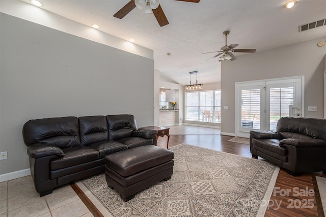 living room featuring visible vents, ceiling fan, baseboards, and wood finished floors