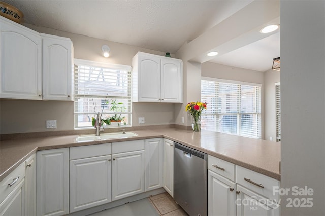 kitchen featuring a sink, a textured ceiling, white cabinets, and stainless steel dishwasher