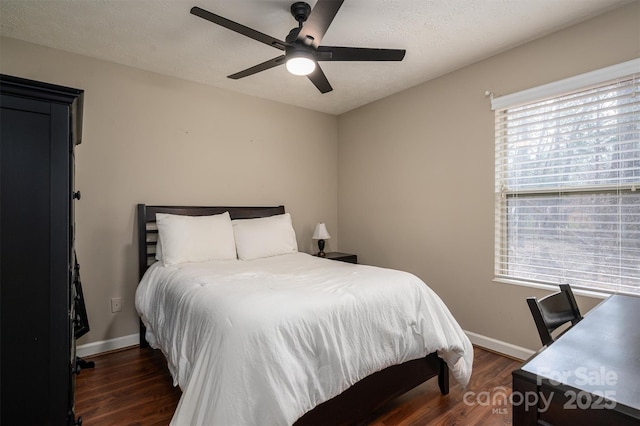 bedroom with ceiling fan, baseboards, and dark wood finished floors