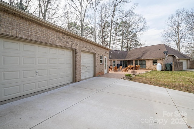 view of front facade with an attached garage, concrete driveway, brick siding, and a front yard