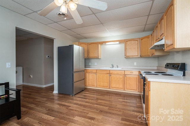 kitchen with under cabinet range hood, electric range, dark wood-type flooring, visible vents, and freestanding refrigerator