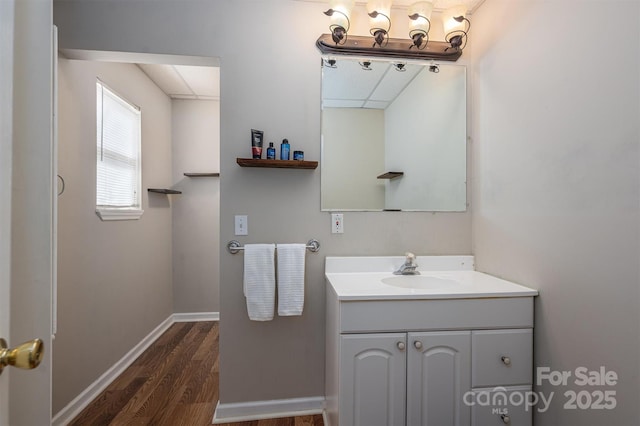 bathroom featuring baseboards, wood finished floors, and vanity