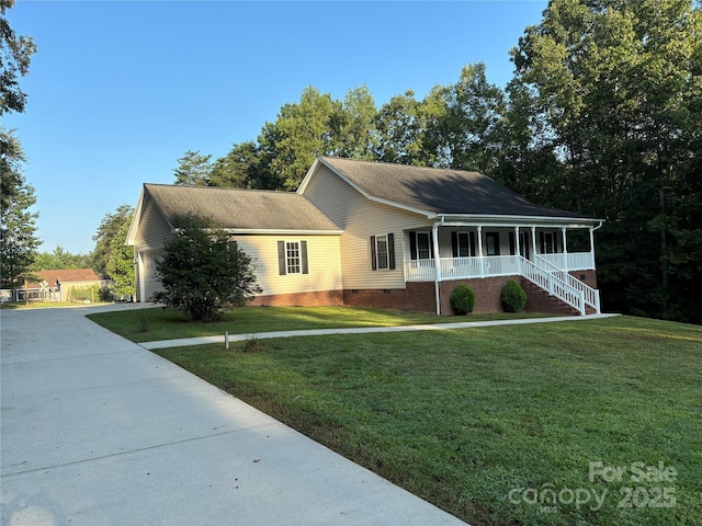 view of front of home featuring a garage, a front yard, and covered porch