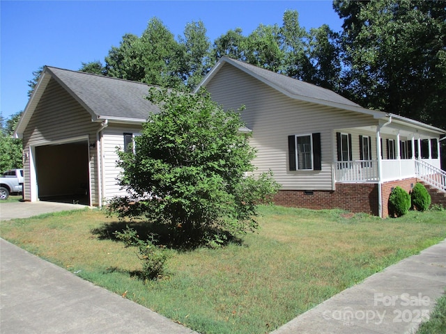 view of home's exterior featuring a porch, a garage, and a yard