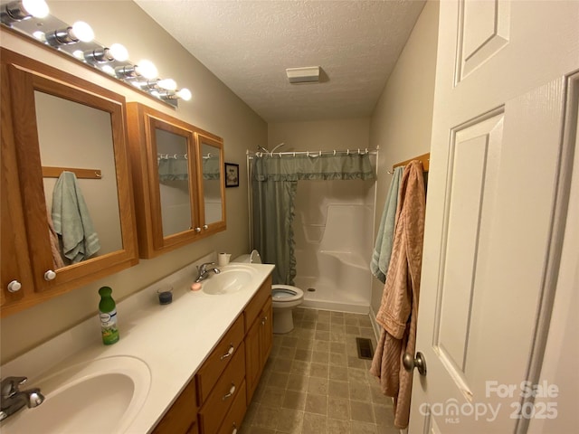 bathroom with vanity, toilet, a shower with shower curtain, and a textured ceiling