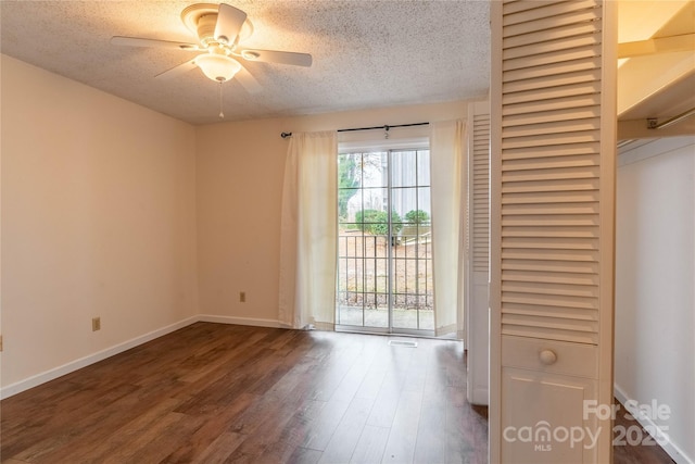 unfurnished room with dark wood-type flooring, ceiling fan, and a textured ceiling