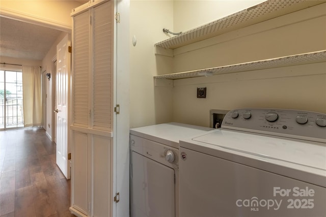 clothes washing area featuring hardwood / wood-style flooring and washer and dryer